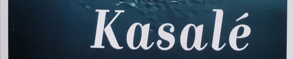 Vor einem in verschiedenen Schattierungen von Dunkelblau gehaltenen Hintergrund steht in weiß das Wort "Kasalé". - Ausschnitt aus dem Buchcover.